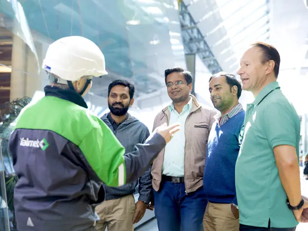 Group of people at a mill with a Valmet representative.