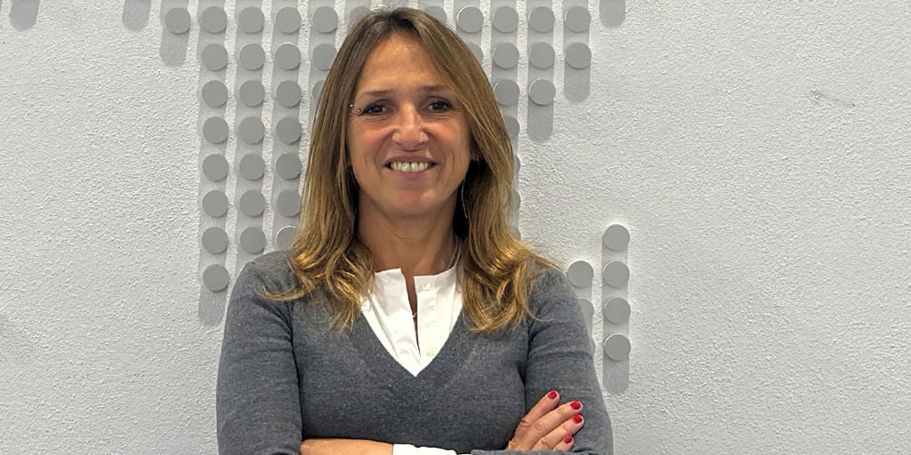 A woman smiling and posing to the camera while having her arms crossed.