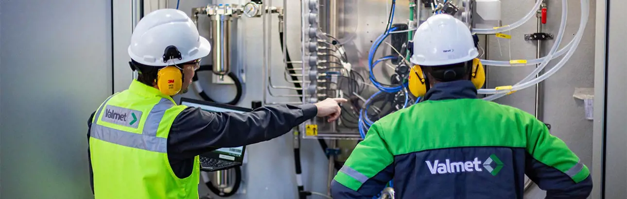 Two Valmet workers looking at an Valmet analyzer 