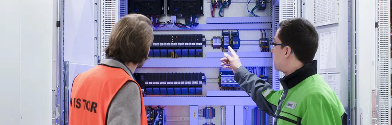An automation manager and field technician inspect I/O and controllers of a distributed control system (DCS)