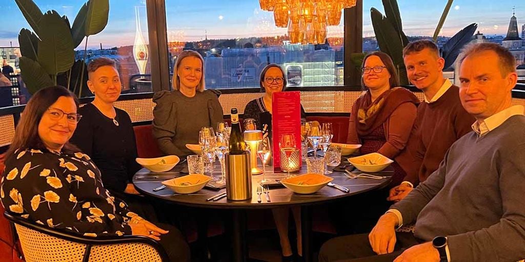 The team celebrating Vesa's graduation over dinner