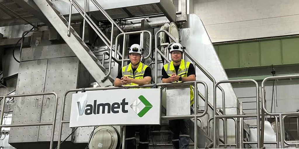 Valmet PRO trainees, Aapo and Jonne standing in front of a Valmet paper machine 