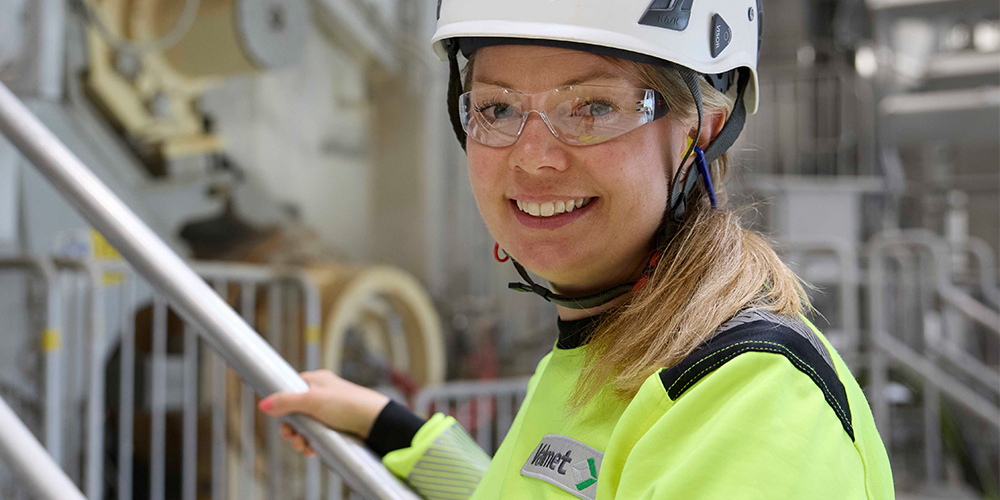 Valmet employee standing in front of a Valmet Advantage DCT tissue machine